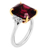 Three-stone ring with garnet center stone and diamond side stones in 18K yellow gold and platinum