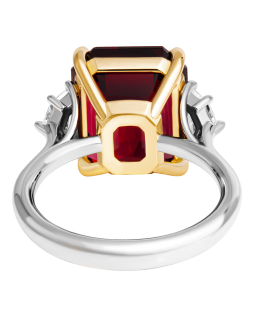 Three-stone ring with garnet center stone and diamond side stones in 18K yellow gold and platinum